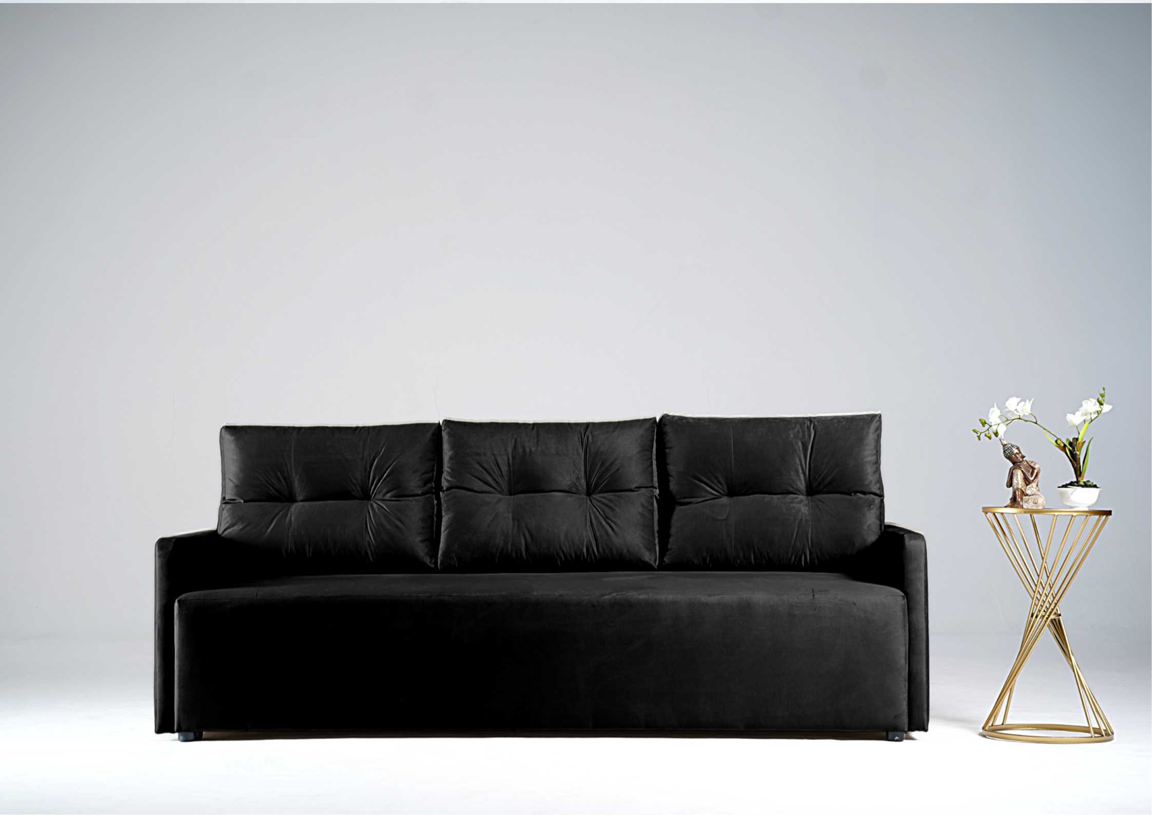 Czarna sofa z pikowanymi poduszkami